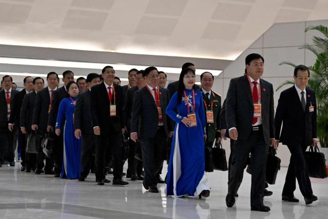 Delegates arrive to attend the opening ceremony of the 14th National Congress of the Communist Party of Vietnam at the National Convention Centre in Hanoi on January 20,2026. (Photo by Nhac NGUYEN / AFP)