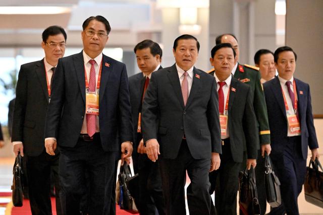 Delegates arrive to attend the opening ceremony of the 14th National Congress of the Communist Party of Vietnam at the National Convention Centre in Hanoi on January 20,2026. (Photo by Nhac NGUYEN / AFP)