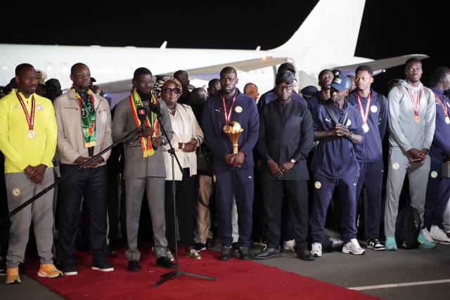 Senegal president Bassirou Diomaye Faye (3rd L) addresses members of Senegal’s national football team upon their arrival in Dakar on January 20, 2025. Senegal’s national football team, crowned African Nations champion thanks to its victory over Morocco on Sunday in Rabat after a high-octane final, landed late Monday night back home, where it was warmly welcomed off the plane by the Senegalese head of state and his government.
The Lions of Teranga, who arrived on a special flight shortly before midnight local time and GMT from Morocco, were congratulated by Senegalese President Bassirou Diomaye Faye, Prime Minister Ousmane Sonko, and members of the government, an AFP journalist observed. (Photo by Carmen Abd Ali / AFP)
