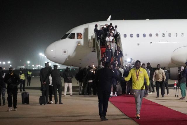 TOPSHOT - Senegal head Coach Pape Thiaw (R) is greeted as he disembark the plane together with Senegal’s national football in Dakar on January 20, 2025. Senegal’s national football team, crowned African Nations champion thanks to its victory over Morocco on Sunday in Rabat after a high-octane final, landed late Monday night back home, where it was warmly welcomed off the plane by the Senegalese head of state and his government.
The Lions of Teranga, who arrived on a special flight shortly before midnight local time and GMT from Morocco, were congratulated by Senegalese President Bassirou Diomaye Faye, Prime Minister Ousmane Sonko, and members of the government, an AFP journalist observed. (Photo by Carmen Abd Ali / AFP)