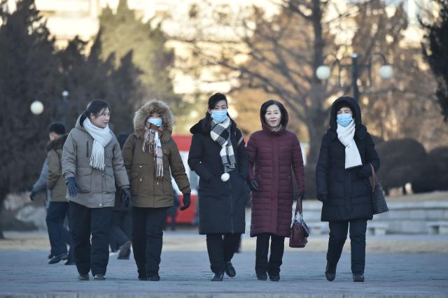 People walk in the street amid cold weather in Pyongyang on January 20, 2026. (Photo by KIM Won Jin / AFP)