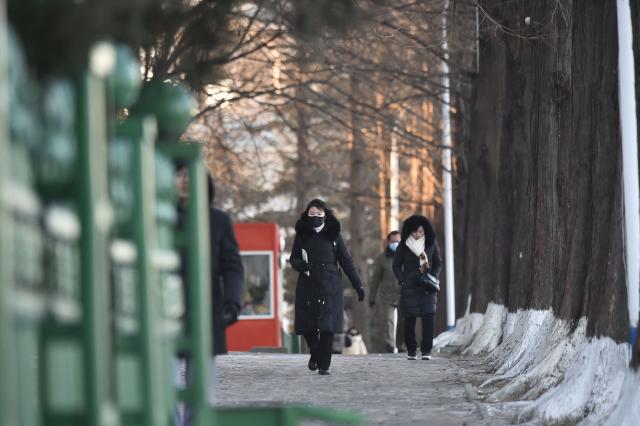 People walk in the street amid cold weather in Pyongyang on January 20, 2026. (Photo by KIM Won Jin / AFP)