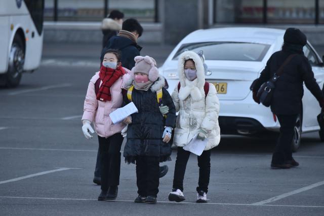 People walk in the street amid cold weather in Pyongyang on January 20, 2026. (Photo by KIM Won Jin / AFP)