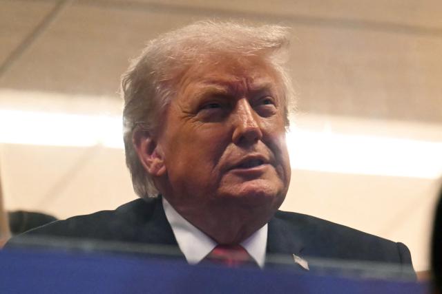 US President Donald Trump attends the College Football National Championship Game between the Miami Hurricanes and the Indiana Hoosiers at Hard Rock Stadium in Miami Gardens, Florida, on January 19, 2026. (Photo by ANDREW CABALLERO-REYNOLDS / AFP)