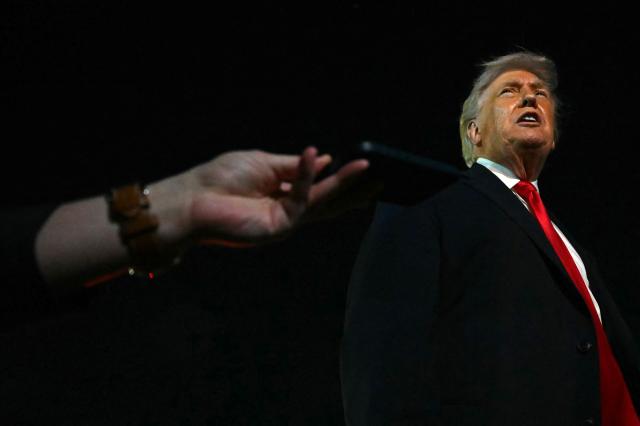 US President Donald Trump speaks with reporters before boarding Air Force One at Palm Beach International Airport, in West Palm Beach, Florida on January 19, 2026. President Trump is returning to Washington after spending the weekend at his Mar-a-Lago residence and attending the College Football National Championship Game between Miami Hurricanes and Indiana Hoosiers at Hard Rock Stadium in Miami Gardens, Florida. (Photo by ANDREW CABALLERO-REYNOLDS / AFP)