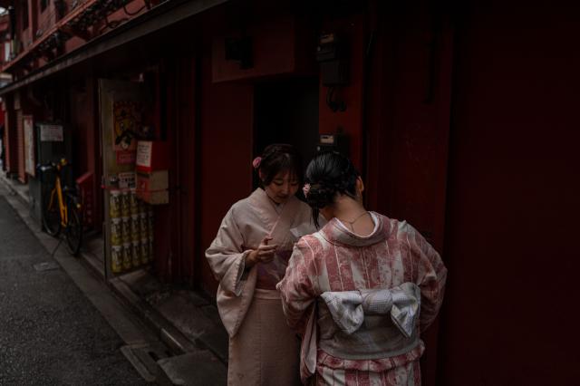 People visit a shopping street in Asakusa district near Sensoji Temple, a popular tourist location in Tokyo on January 20, 2026. A record number of tourists flocked to Japan in 2025, officials said on January 20, despite a steep fall in Chinese visitors in December as a diplomatic row between Beijing and Tokyo rumbled on. (Photo by Philip FONG / AFP)