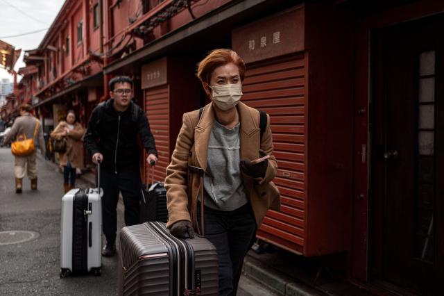 People visit a shopping street in Asakusa district near Sensoji Temple, a popular tourist location in Tokyo on January 20, 2026. A record number of tourists flocked to Japan in 2025, officials said on January 20, despite a steep fall in Chinese visitors in December as a diplomatic row between Beijing and Tokyo rumbled on. (Photo by Philip FONG / AFP)