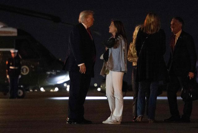 US President Donald Trump (L) talks with his granddaughter Kai Trump before boarding Air Force One at Palm Beach International Airport, in West Palm Beach, Florida on January 19, 2026. President Trump is returning to Washington after spending the weekend at his Mar-a-Lago residence and attending the College Football National Championship Game between Miami Hurricanes and Indiana Hoosiers at Hard Rock Stadium in Miami Gardens, Florida. (Photo by ANDREW CABALLERO-REYNOLDS / AFP)