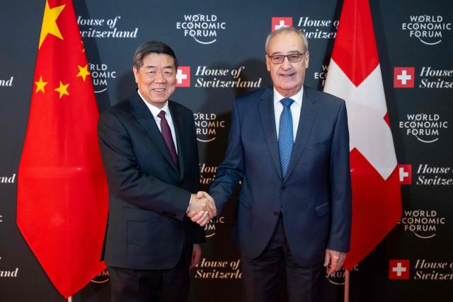 Switzerland's President Guy Parmelin (R) shakes hands with China’s Vice Premier He Lifeng prior to a bilateral meeting on the sidelines of the World Economic Forum (WEF) annual meeting in Davos on January 20, 2026. The World Economic Forum takes place in Davos from January 19 to January 23, 2026. (Photo by LAURENT GILLIERON / POOL / AFP)