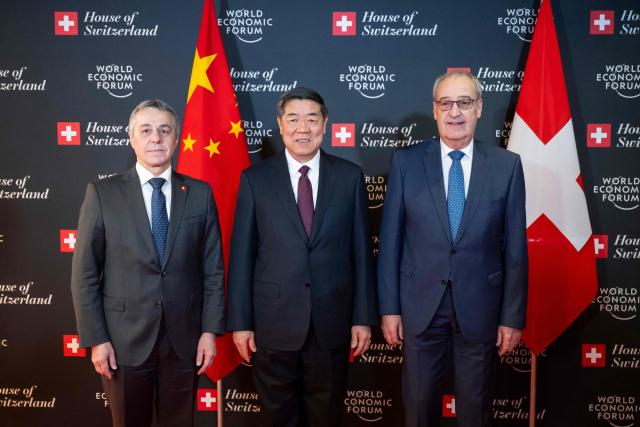 Switzerland's President Guy Parmelin (R), flanked by Switzerland's Foreign Minister Ignazio Cassis (L), welcomes China’s Vice Premier He Lifeng prior to a bilateral meeting on the sidelines of the World Economic Forum (WEF) annual meeting in Davos on January 20, 2026. The World Economic Forum takes place in Davos from January 19 to January 23, 2026. (Photo by LAURENT GILLIERON / POOL / AFP)