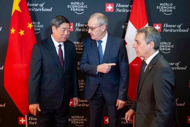 Switzerland's President Guy Parmelin (C), flanked by Switzerland's Foreign Minister Ignazio Cassis (R), welcomes China’s Vice Premier He Lifeng prior to a bilateral meeting on the sidelines of the World Economic Forum (WEF) annual meeting in Davos on January 20, 2026. The World Economic Forum takes place in Davos from January 19 to January 23, 2026. (Photo by LAURENT GILLIERON / POOL / AFP)