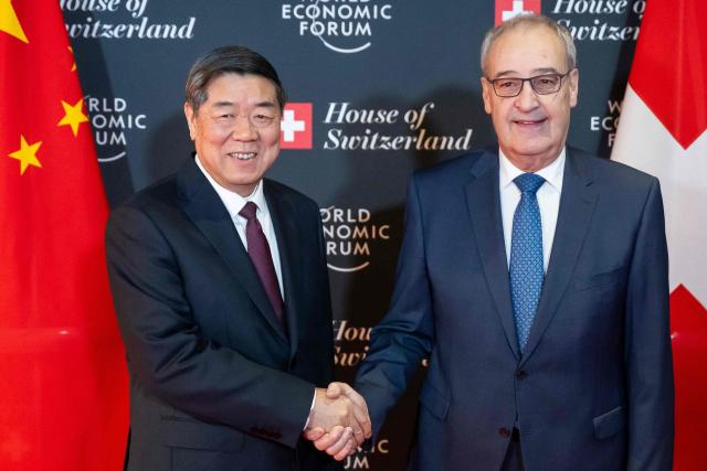 Switzerland's President Guy Parmelin (R) shakes hands with China’s Vice Premier He Lifeng prior to a bilateral meeting on the sidelines of the World Economic Forum (WEF) annual meeting in Davos on January 20, 2026. The World Economic Forum takes place in Davos from January 19 to January 23, 2026. (Photo by LAURENT GILLIERON / POOL / AFP)