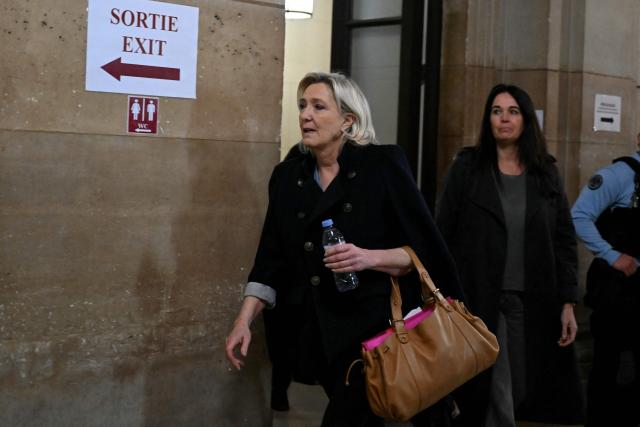 President of the parliamentary group of the French far-right Rassemblement National (RN) party, Marine Le Pen (L) accompanied by Rassemblement National MEP Catherine Griset (R) arrives for the hearing in the appeal trial of Rassemblement National (RN) parliamentary assistants on suspicion of embezzlement of European public funds at Paris courthouse in Paris on January 20, 2026. Marine Le Pen is called to the stand in the appeal trial in Paris of the parliamentary assistants of the National Front, where she is playing for her candidacy for the 2027 presidential election. Twelve of the accused, as well as the far-right party itself, have appealed against the verdict while another 12 people -- including one of Le Pen's sisters -- have decided to accept their convictions without appealing. (Photo by Bertrand GUAY / AFP)