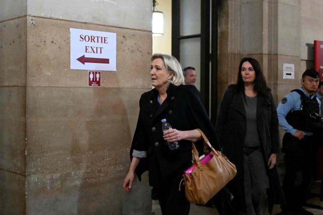 President of the parliamentary group of the French far-right Rassemblement National (RN) party, Marine Le Pen (L) accompanied by Rassemblement National MEP Catherine Griset (C) arrives for the hearing in the appeal trial of Rassemblement National (RN) parliamentary assistants on suspicion of embezzlement of European public funds at Paris courthouse in Paris on January 20, 2026. Marine Le Pen is called to the stand in the appeal trial in Paris of the parliamentary assistants of the National Front, where she is playing for her candidacy for the 2027 presidential election. Twelve of the accused, as well as the far-right party itself, have appealed against the verdict while another 12 people -- including one of Le Pen's sisters -- have decided to accept their convictions without appealing. (Photo by Bertrand GUAY / AFP)