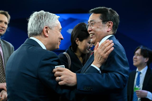 Canada's Minister of Finance Francois-Philippe Champagne (L) greets Japan's Minister of Economy, Trade and Industry Ryosei Akazawa during the World Economic Forum (WEF) annual meeting in Davos on January 20, 2026. The World Economic Forum takes place in Davos from January 19 to January 23, 2026. (Photo by Fabrice COFFRINI / AFP)