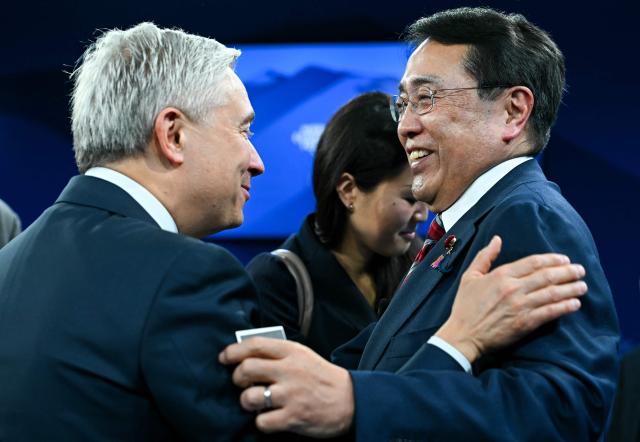 Canada's Minister of Finance Francois-Philippe Champagne (L) greets Japan's Minister of Economy, Trade and Industry Ryosei Akazawa during the World Economic Forum (WEF) annual meeting in Davos on January 20, 2026. The World Economic Forum takes place in Davos from January 19 to January 23, 2026. (Photo by Fabrice COFFRINI / AFP)