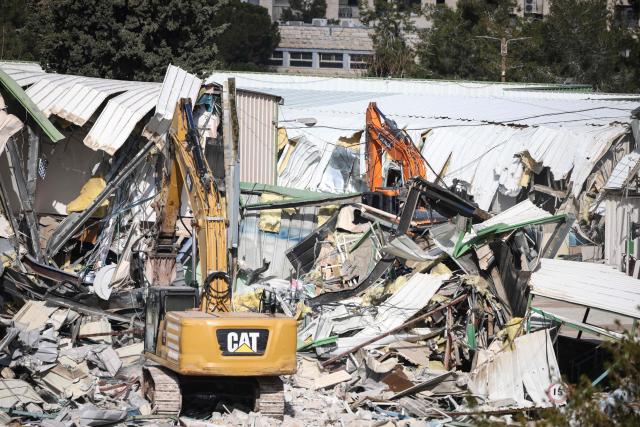 A photograph shows heavy machinery demolishing a structure inside the headquarters of the United Nations Relief and Works Agency (UNRWA) in the Sheikh Jarrah neighbourhood of Israeli-annexed east Jerusalem on January 20, 2026. The chief of the UN's agency for Palestinian refugees denounced the Israeli authorities' seizure of assets from its east Jerusalem compound earlier this month, which police told AFP was part of a debt-collection operation. The compound in Israeli-annexed east Jerusalem has been empty of UNRWA staff since January, when the law banning its operations took effect after a months-long battle over its work in the Gaza Strip. Israel had accused UNRWA of providing cover for Hamas militants, and the legislation also forbids contact between the agency and Israeli officials. (Photo by ilia yefimovich / AFP)