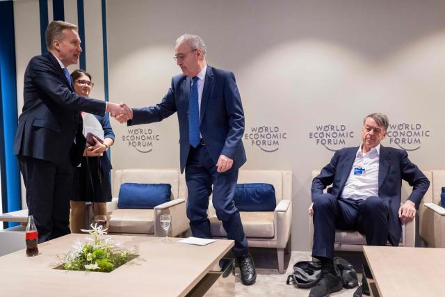World Economic Forum president and CEO Borge Brende (L) shakes hands with Switzerland's President Guy Parmelin (C) next to WEF co-chairman Andre Hoffmann (R) during the World Economic Forum (WEF) annual meeting in Davos on January 20, 2026. The World Economic Forum takes place in Davos from January 19 to January 23, 2026. (Photo by LAURENT GILLIERON / POOL / AFP)