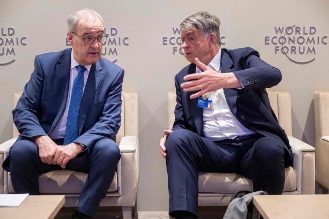 Switzerland's President Guy Parmelin (L) speaks with WEF co-chairman Andre Hoffmann during the World Economic Forum (WEF) annual meeting in Davos on January 20, 2026. The World Economic Forum takes place in Davos from January 19 to January 23, 2026. (Photo by LAURENT GILLIERON / POOL / AFP)