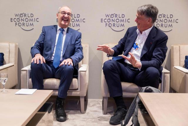 Switzerland's President Guy Parmelin (L) speaks with WEF co-chairman Andre Hoffmann during the World Economic Forum (WEF) annual meeting in Davos on January 20, 2026. The World Economic Forum takes place in Davos from January 19 to January 23, 2026. (Photo by LAURENT GILLIERON / POOL / AFP)