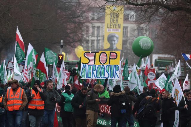 Farmers hold placards and flags as European farmers march towards the European Parliament to protest against the free trade agreement between the European Union and the Mercosur countries, on the eve of a vote on a referral to the courts, in Strasbourg on January 20, 2026. Called by the FNSEA, France's leading national agricultural union, some 4,000 farmers from across the European Union, including Italy, Belgium, and Germany, are expected to attend the protest. MEPs will not vote on the entire agreement with Mercosur until the coming months, but they are set to vote on Wednesday on whether to refer the matter to the Court of Justice of the European Union (CJEU). (Photo by FREDERICK FLORIN / AFP)
