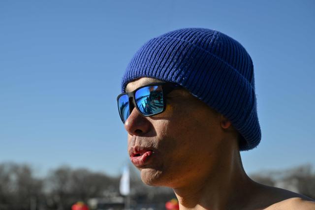 Zhang Xin, a winter swimming enthusiast prepares to swim at the Houhai Lake of the Shichahai scenic area in Beijing on January 20, 2026. Every winter dozens of locals add to their daily routine a frigid lap in the icy waters of Shichahai, a sprawling lake in the center of the Chinese capital. (Photo by Adek BERRY / AFP)