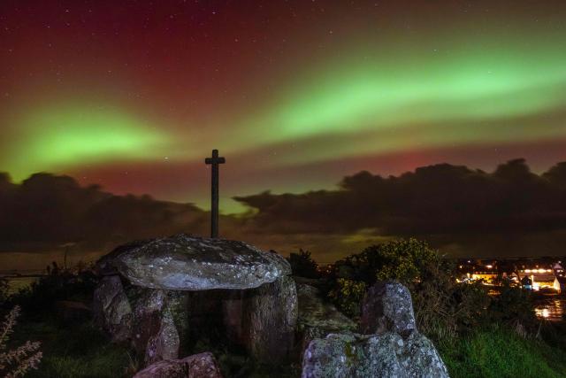 Aurora Borealis, or Northern Lights, are seen over a dolmen, an 8000-year-old megalith, following a powerful sunstorm in Guilliguy, western France, on January 19, 2026. (Photo by Oscar Chuberre / AFP)