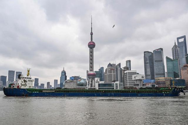A cargo ship sails along the Huangpu River in Shanghai on January 20, 2026. (Photo by Hector RETAMAL / AFP)