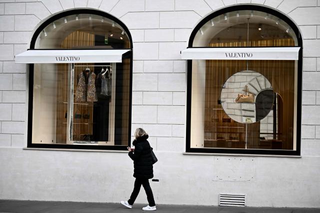 A woman walks past Valentino's flagship store in Rome a day after the death of fashion designer Valentino Garavani at the age of 93, on January 20, 2026. (Photo by Filippo MONTEFORTE / AFP)