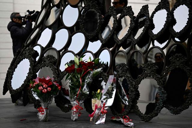 Flowers are laid by a work of art in front of Valentino's headquarters a day after the death of fashion designer Valentino Garavani at the age of 93, in Rome on January 20, 2026. (Photo by Filippo MONTEFORTE / AFP)