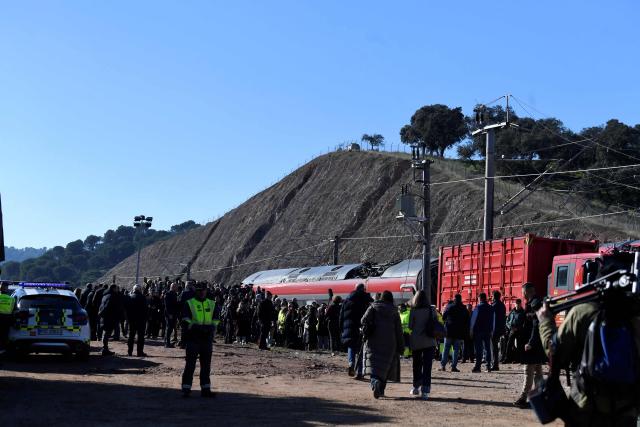 Journalists arrive on the site of a high-speed trains collision that killed at least 41 people two days before, in Adamuz, southern Spain, on January 20, 2026. At least 41 people died and more than 120 injured in the deadliest train accident in Spain in over a decade. The crash happened on January 18 evening when a train operated by rail company Iryo travelling from Malaga to Madrid derailed near Adamuz, crossing onto the other track where it crashed into an oncoming train, which also derailed. (Photo by CRISTINA QUICLER / AFP)