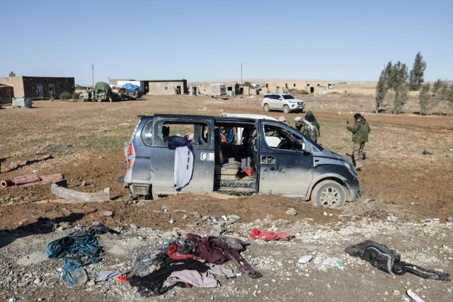 Syrian soldiers inspect a bullet-riddled vehicle on the side of a road in the area of Khirbat At Tamr, south of the city of Hasakeh in northeastern Syria, on January 20, 2026, as Syrian government forces head towards the city. Negotiations have collapsed between the Syrian president and the chief of the country's Kurdish-led forces, a Kurdish official told AFP, as the army deployed reinforcements to flashpoint areas in the north. (Photo by Bakr ALkasem / AFP)