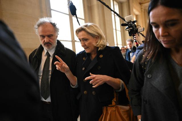 President of the parliamentary group of the French far-right Rassemblement National (RN) party, Marine Le Pen (C) speaks with her lawyer Rodolphe Bosselut (L) as she leaves with former member of the European Parliament Catherine Griset (R) the Palais de Justice de Paris in a break during their appeal trial on charges of embezzlement of European public funds in a case of alleged European Parliament fake jobs in Paris on January 20, 2026. Marine Le Pen is called to the stand in the appeal trial in Paris of the parliamentary assistants of the National Front, where she is playing for her candidacy for the 2027 presidential election. Twelve of the accused, as well as the far-right party itself, have appealed against the verdict while another 12 people -- including one of Le Pen's sisters -- have decided to accept their convictions without appealing. (Photo by Bertrand GUAY / AFP)