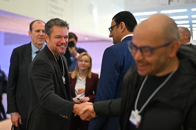 US actor Matt Damon shakes hands during the World Economic Forum (WEF) annual meeting in the Congress centre in Davos on January 20, 2026. The World Economic Forum takes place in Davos from January 19 to January 23, 2026. (Photo by Fabrice COFFRINI / AFP)