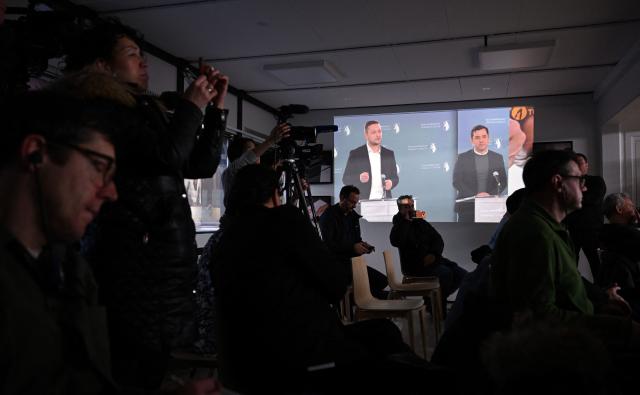Journalists sitting in a press room follow a press conference of Greenland's Prime Minister Jens-Frederik Nielsen (C-L) and Greenland's Minister for Finance and Taxes Múte Bourup Egede (C-R) displayed on a screen in the background, on January 20, 2026 in Greenland's capital Nuuk. (Photo by Jonathan Nackstrand / AFP)