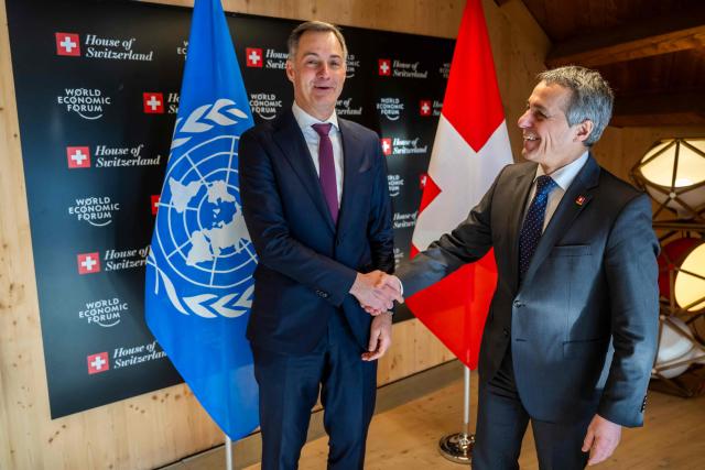 Administrator of the United Nations Development Programme (UNDP) Belgian Alexander De Croo (L) shakes hands with Switzerland's Foreign Minister Ignazio Cassis prior to a bilateral meeting during the World Economic Forum (WEF) annual meeting in Davos on January 20, 2026. The World Economic Forum takes place in Davos from January 19 to January 23, 2026. (Photo by LAURENT GILLIERON / POOL / AFP)