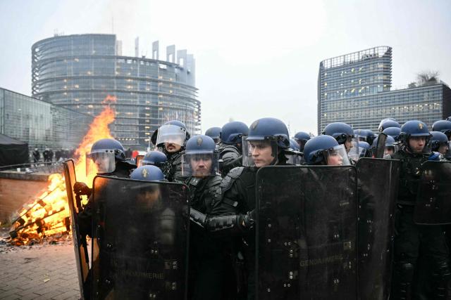 Gendarmes in riot gear walk back in formation as they face protesters outside the European Parliament building during a protest against the free trade agreement between the European Union and the Mercosur countries, on the eve of a vote on a referral to the courts, in Strasbourg on January 20, 2026. Called by the FNSEA, France's leading national agricultural union, some 4,000 farmers from across the European Union, including Italy, Belgium, and Germany, are expected to attend the protest. MEPs will not vote on the entire agreement with Mercosur until the coming months, but they are set to vote on Wednesday on whether to refer the matter to the Court of Justice of the European Union (CJEU). (Photo by NICOLAS TUCAT / AFP)