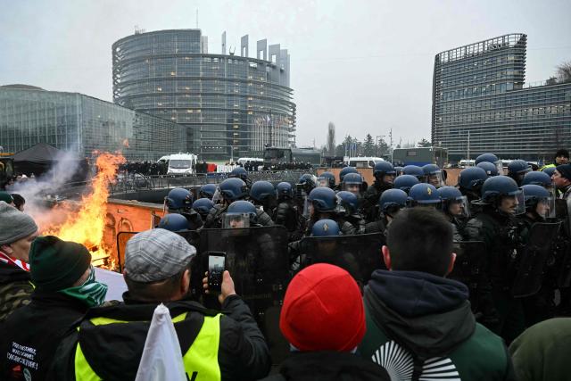 Gendarmes in riot gear stand in formation as they face protesters outside the European Parliament building during a protest against the free trade agreement between the European Union and the Mercosur countries, on the eve of a vote on a referral to the courts, in Strasbourg on January 20, 2026. Called by the FNSEA, France's leading national agricultural union, some 4,000 farmers from across the European Union, including Italy, Belgium, and Germany, are expected to attend the protest. MEPs will not vote on the entire agreement with Mercosur until the coming months, but they are set to vote on Wednesday on whether to refer the matter to the Court of Justice of the European Union (CJEU). (Photo by NICOLAS TUCAT / AFP)