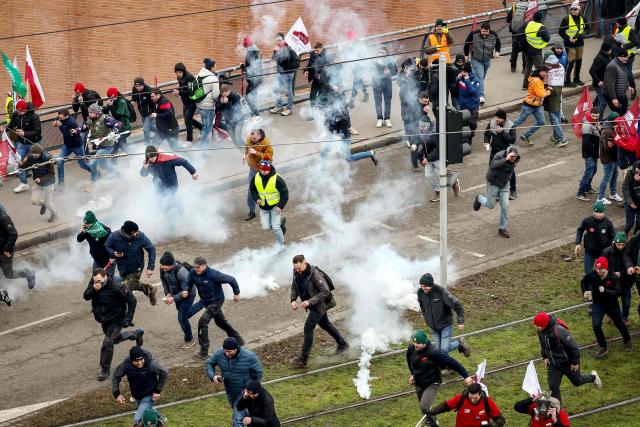 Protesters run away from tear gas outside the European Parliament building during a protest against the free trade agreement between the European Union and the Mercosur countries, on the eve of a vote on a referral to the courts, in Strasbourg on January 20, 2026. Called by the FNSEA, France's leading national agricultural union, some 4,000 farmers from across the European Union, including Italy, Belgium, and Germany, are expected to attend the protest. MEPs will not vote on the entire agreement with Mercosur until the coming months, but they are set to vote on whether to refer the matter to the Court of Justice of the European Union (CJEU). (Photo by FREDERICK FLORIN / AFP)