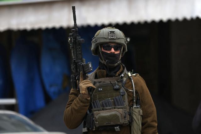 A soldier stands guard after the Israel army closed part of the H2 southern sector of the occupied West Bank city of Hebron, and announced a curfew as they search for weapons and Palestinians on their wanted list, on January 20, 2026. Following the 1995 Oslo Agreement and subsequent 1997 Hebron Agreement, Palestinian cities in the West Bank were placed under the exclusive jurisdiction of the Palestinian Authority, with the exception of Hebron, which was split into two sectors: H1 is controlled by the Palestinian Authority and H2 – which includes the Old City of Hebron – remaining under the military control of Israel. Most Palestinians live in the H2 sector. (Photo by HAZEM BADER / AFP)