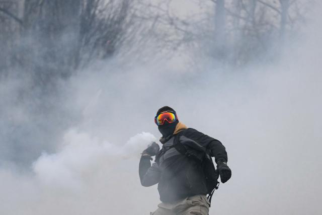 A protester throws back a tear gas canister during clashes with police outside the European Parliament building during a protest against the free trade agreement between the European Union and the Mercosur countries, on the eve of a vote on a referral to the courts, in Strasbourg on January 20, 2026. Called by the FNSEA, France's leading national agricultural union, some 4,000 farmers from across the European Union, including Italy, Belgium, and Germany, are expected to attend the protest. MEPs will not vote on the entire agreement with Mercosur until the coming months, but they are set to vote on Wednesday on whether to refer the matter to the Court of Justice of the European Union (CJEU). (Photo by NICOLAS TUCAT / AFP)