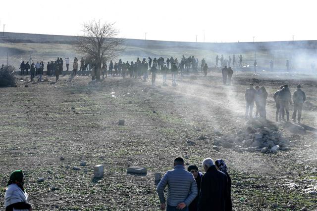 Protesters enter a buffer zone during a rally against an offensive of Syrian government forces against Kurdish forces, near Nusaybin border gate in Mardin, on the Turkey-Syria border, on January 20, 2026. Clashes erupted on Turkey's border with Syria on between police and pro-Kurdish protesters angered by a Syrian military offensive targeting Kurds, an AFP correspondent said. The violence broke out in the border town of Nusaybin, just across from the northern Syrian town of Qamishli, at a protest called by the pro-Kurdish DEM, Turkey's third-largest party. (Photo by Ilyas AKENGIN / AFP)