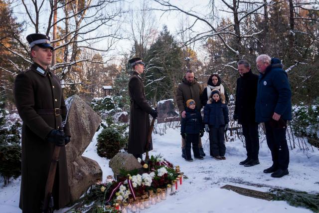 Relatives of Gvido Zvaigzne, cinematographer and camera operator, victim of the January 1991 events, pay their respect at a burial site of the 2nd Forest Cemetery in Riga, Latvia on January 20, 2026 during a remembrance ceremony for those who died during the 1991 "Barricades" on January 20, 1991. Latvia marks the 35th anniversary of the events known as the 1991 "Barricades", when supporters of Latvian independence non-violently defended the country's freedom against military attacks and opponents of independence. (Photo by Gints Ivuskans / AFP)