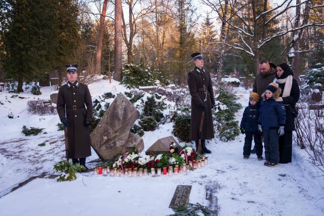 Relatives of Gvido Zvaigzne, cinematographer and camera operator, victim of the January 1991 events, pay their respect at a burial site of the 2nd Forest Cemetery in Riga, Latvia on January 20, 2026 during a remembrance ceremony for those who died during the 1991 "Barricades" on January 20, 1991. Latvia marks the 35th anniversary of the events known as the 1991 "Barricades", when supporters of Latvian independence non-violently defended the country's freedom against military attacks and opponents of independence. (Photo by Gints Ivuskans / AFP)