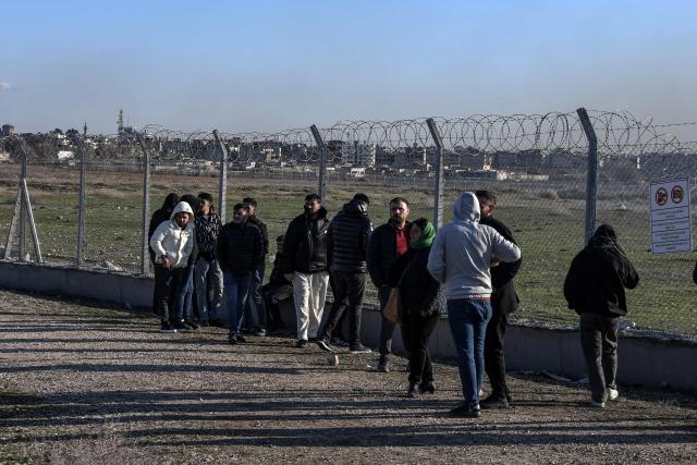 Protesters stand at a fence as others enter buffer zone during a rally against an offensive of Syrian government forces against Kurdish forces, near Nusaybin border gate in Mardin, on the Turkey-Syria border, on January 20, 2026. Clashes erupted on Turkey's border with Syria on between police and pro-Kurdish protesters angered by a Syrian military offensive targeting Kurds, an AFP correspondent said. The violence broke out in the border town of Nusaybin, just across from the northern Syrian town of Qamishli, at a protest called by the pro-Kurdish DEM, Turkey's third-largest party. (Photo by Ilyas AKENGIN / AFP)