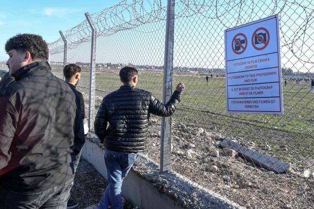 Protesters stand at a fence as others enter buffer zone during a rally against an offensive of Syrian government forces against Kurdish forces, near Nusaybin border gate in Mardin, on the Turkey-Syria border, on January 20, 2026. Clashes erupted on Turkey's border with Syria on between police and pro-Kurdish protesters angered by a Syrian military offensive targeting Kurds, an AFP correspondent said. The violence broke out in the border town of Nusaybin, just across from the northern Syrian town of Qamishli, at a protest called by the pro-Kurdish DEM, Turkey's third-largest party. (Photo by Ilyas AKENGIN / AFP)