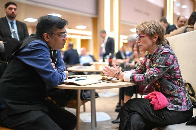 Secretary General of Amnesty International Agnes Callamard (R) speaks with Executive Director of Oxfam International Amitabh Behar during the World Economic Forum (WEF) annual meeting in Davos on January 20, 2026. The World Economic Forum takes place in Davos from January 19 to January 23, 2026. (Photo by Fabrice COFFRINI / AFP)