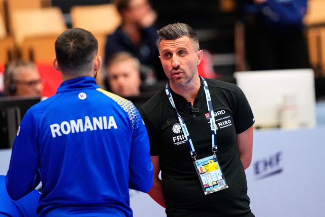 Romania's coach George Ionut Buricea (R) reacts prior to the EHF Euro 2026 Group B preliminary round handball match between North Macedonia and Romania in Herning, Denmark, on January 20, 2026. (Photo by Sebastian Elias Uth / Ritzau Scanpix / AFP) / Denmark OUT