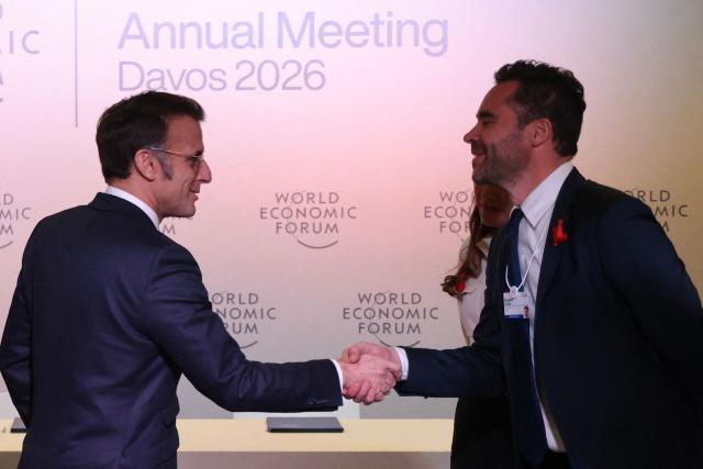 France's President Emmanuel Macron shakes hands with CEO of H Company Gautier Cloix (R) during a meeting with leaders of AI companies during the World Economic Forum (WEF) annual meeting in Davos on January 20, 2026. The World Economic Forum takes place in Davos from January 19 to January 23, 2026. (Photo by Ludovic MARIN / AFP)