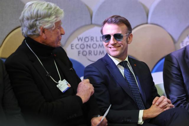 French businessman Maurice Levy and France's President Emmanuel Macron attend a meeting with CEOs of AI companies during the World Economic Forum (WEF) annual meeting in Davos on January 20, 2026. The World Economic Forum takes place in Davos from January 19 to January 23, 2026. (Photo by Ludovic MARIN / AFP)